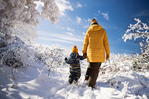 Mom and son enjoying a carefree winter day on the snowy mountain.