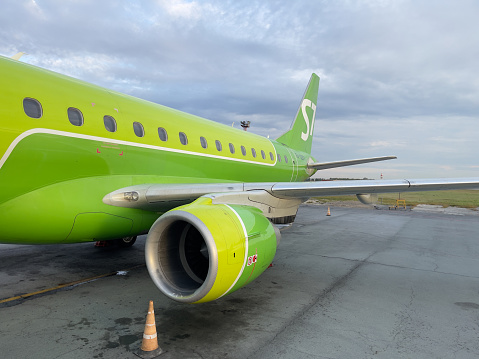 Novosibirsk, Siberia, Russia - September 20, 2023.\nAirplane wing with turbine in close-up. S7 airplane at the airport.