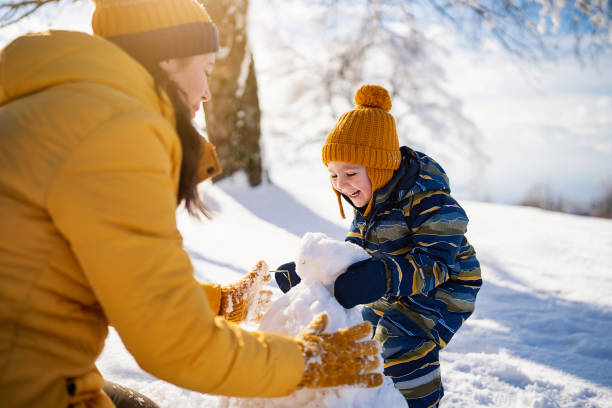 istock Mom and son making a snowman together 1754153304