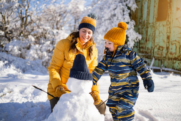 istock Mom and son making a snowman together 1754154469