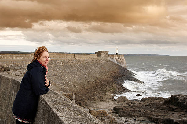 istock Mature windswept woman at sea wall 175415668