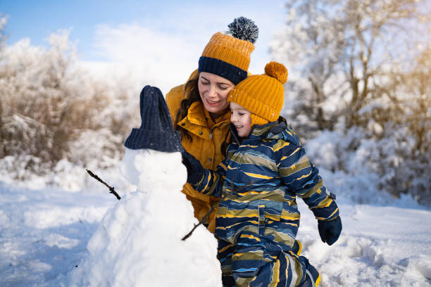 istock Mom and son making a snowman together 1754157265