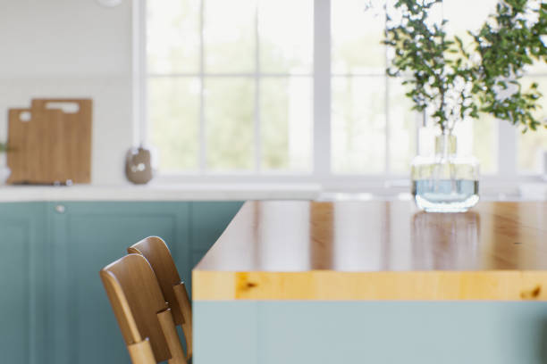 istock Green kitchen with wood countertops and accent island for product display. Empty kitchen countertop with blurred kitchen background with appliances and utensils. 3D rendering. 1754157833