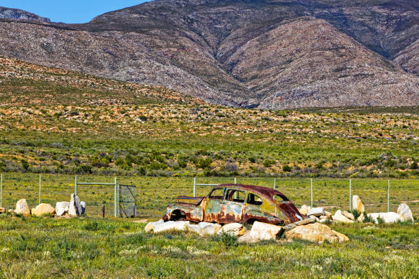 Old car wreck mounted on rocks in Little Karoo near Ladismith in the Western Cape, South Africa