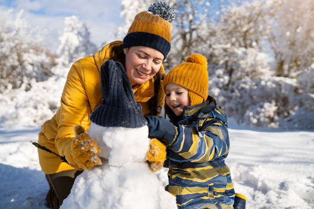 istock Mom and son making a snowman together 1754159061