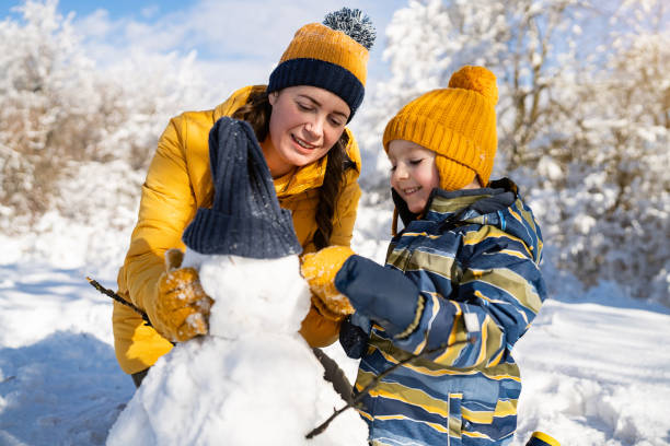 istock Mom and son making a snowman together 1754159062