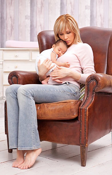 istock mother holding sleeping baby 175416575