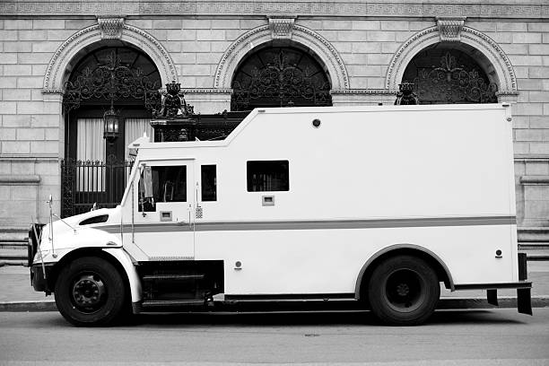 Armored Truck Armored Truck outside of a Large Bank. Black and White Image. armored truck stock pictures, royalty-free photos & images