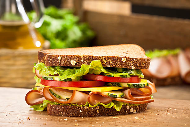 Smoked Ham Sandwich Smoked Ham and Cheese Sandwich on Whole Bread with Tomato and Letucce ham and cheese sandwich stock pictures, royalty-free photos & images