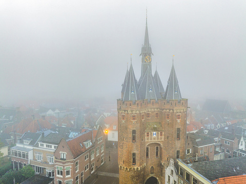 View on the Sassenpoort in the city of Zwolle, Overijssel, The Netherlands during a beautiful summer morning with a hazy fog over the city seen from above.