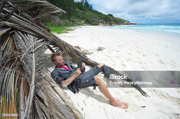 Náufrago Ejecutivo Relaja Con Tableta Digital En La Playa Foto de stock y más banco de imágenes de Robinson Crusoe