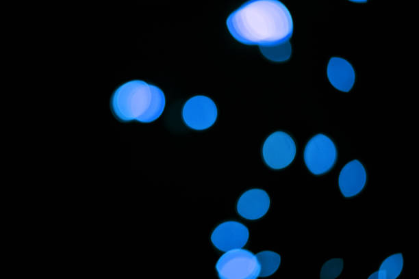 Abstract background in blue tones with defocused bokeh light and dynamic glowing lines.