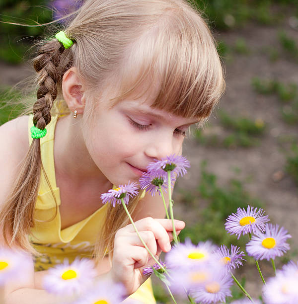 istock girl smelling flower 175418042