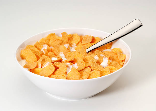 bowl of corn flakes (copos de maíz con cuchara - corn flakes fotografías e imágenes de stock