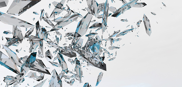 Close-up of falling glass shards against black background.