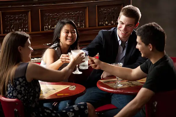 "Young Professionals hang out together at a piano bar/restaurant, enjoying a toast and good conversation."