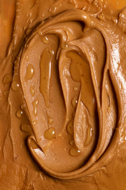 istock Close-up of smooth peanut butter with honey texture. Light brown sweet paste for breakfast toasts, pancakes 1754191055