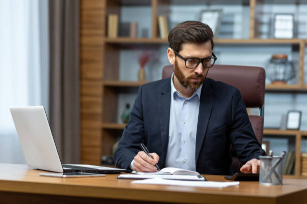 istock Serious thinking businessman behind paper work, senior experienced boss working concentratedly sitting inside office at table, financier investor signing contract 1754192522