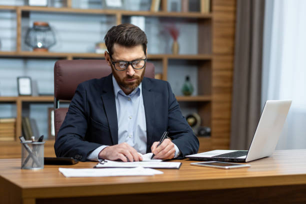 istock Serious thinking businessman behind paper work, senior experienced boss working concentratedly sitting inside office at table, financier investor signing contract 1754192878