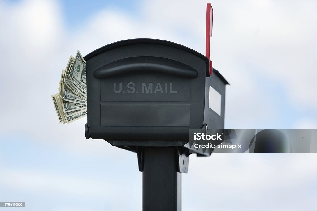 Money in the mail Mailbox with money sticking out with blue skies Currency Stock Photo