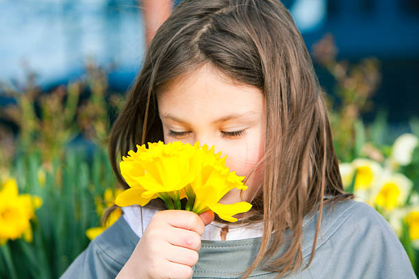 portrait of a beautiful girl walking with a yellow flower in her hands and looking to one side