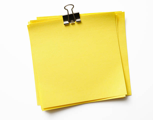 Stacked blank yellow sticky note with paper clip on white With CLIPPING PATH.Stacked blank yellow sticky note isolated on white background with clipping path.Studio shot. paper clip office supply stack heap stock pictures, royalty-free photos & images