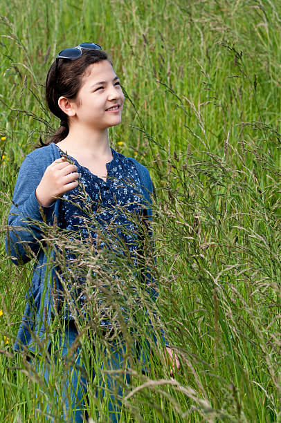 istock Smiling Girl Standing in Tall Grass 175420194