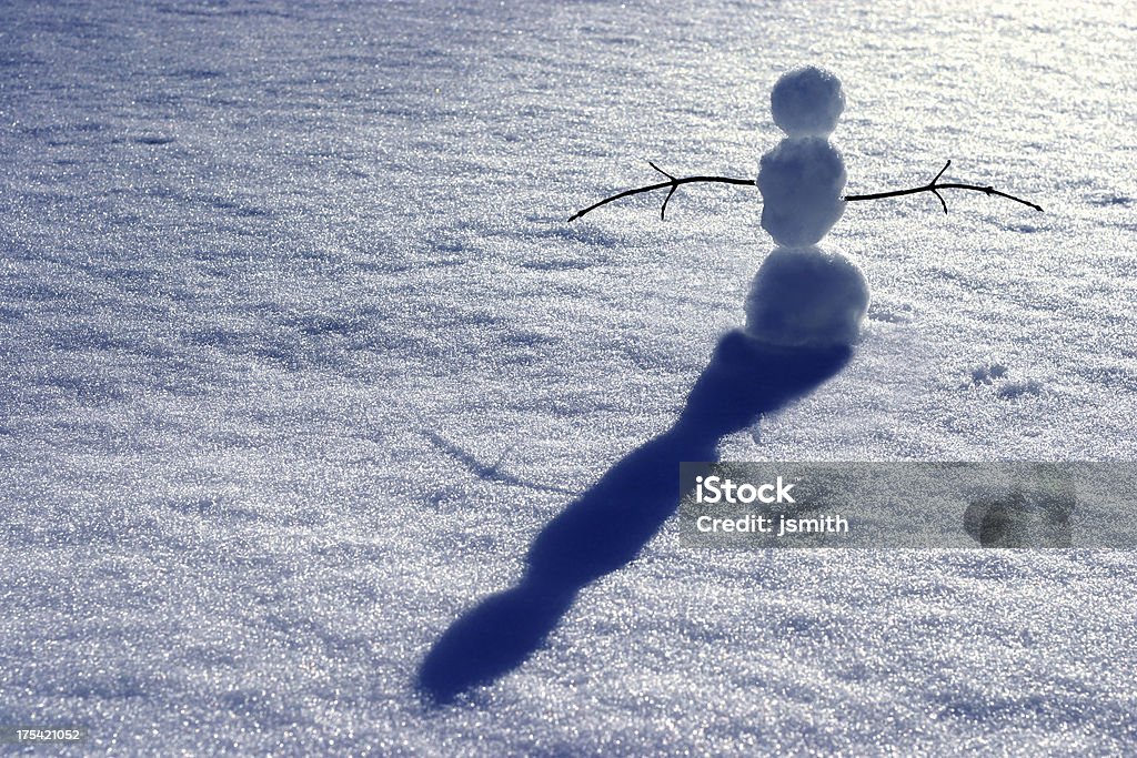 Snow Man Calendar "Snow man basks in the sunlight with harsh late afternoon shadowsMight be good for a calendar image for winter months January, February, March - or maybe a postcard of spring coming for travel industry with room for copy on left top and logo at bottom right" Focus on Shadow Stock Photo