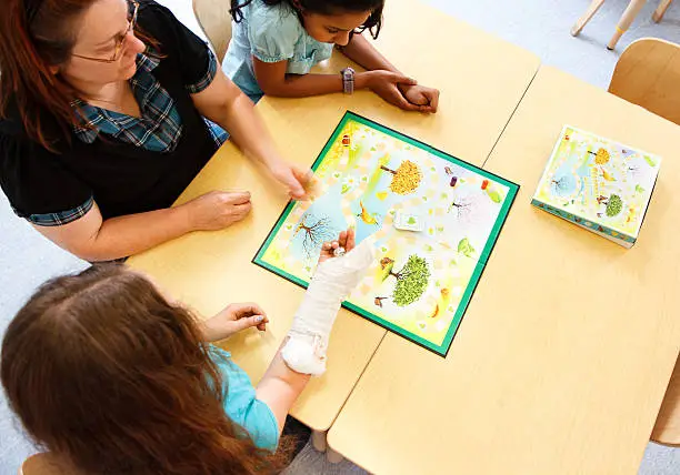 Photo of Teacher & Students Play A Board Game Together