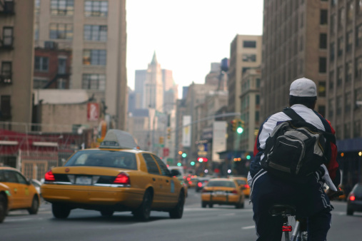 Bicycle messenger in busy downtown New York City street/avenue.