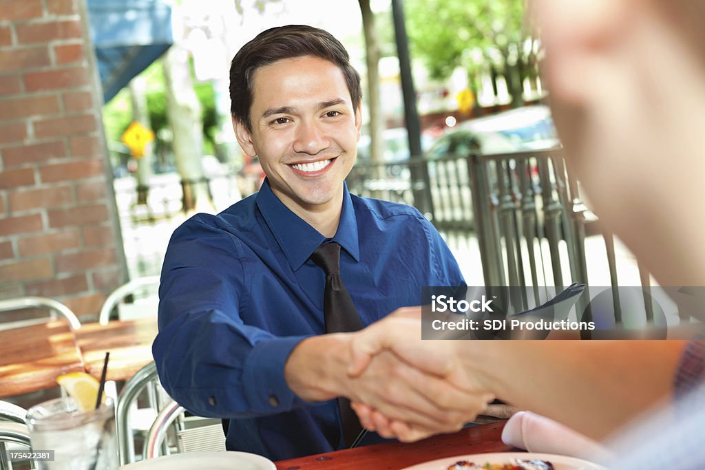 Jeune homme ayant une réunion d'affaires dans le café en plein air - Photo de Café - Établissement de restauration libre de droits