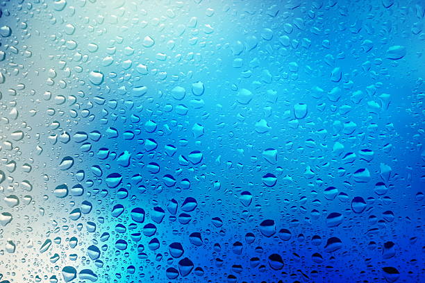 Close up of water droplets on a window Water drops on blue background. blue condensation stock pictures, royalty-free photos & images