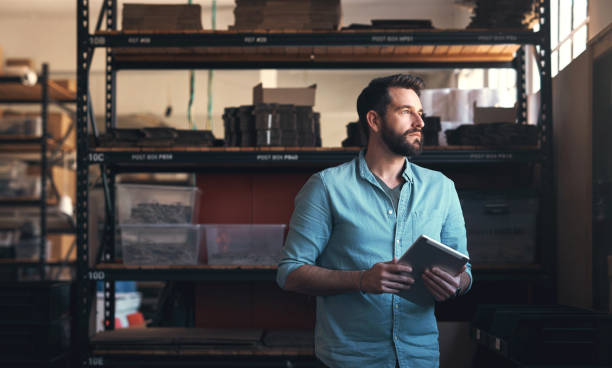 istock Tablet, idea and a man in a maintenance studio for production, manufacturing or repairs. Tech, industry and problem solving for service with a young engineer, designer or technician in a workshop 1754233870