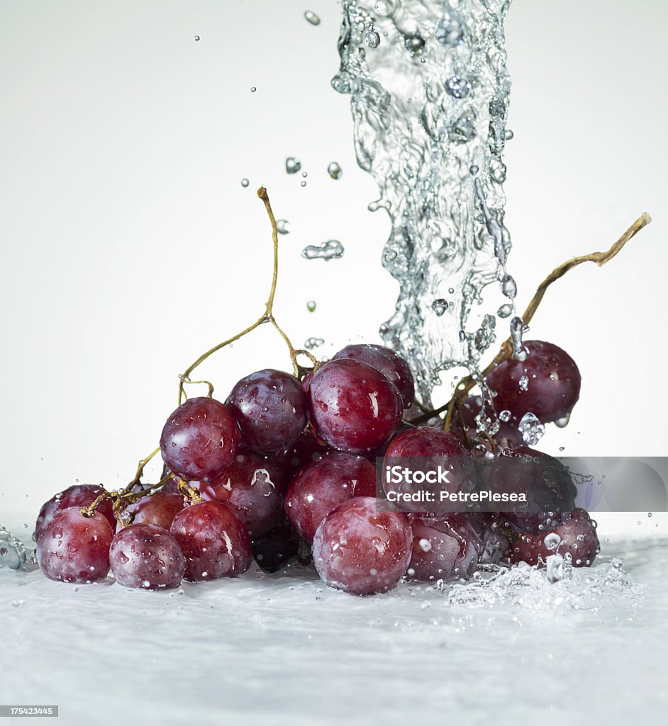 Red Grapes. Water Splash Water Splashing on Green Fresh Grapes. Close Up. Isolated on white. NOTE: Shot with Highres Camera Hasselblad H4D 50 megapixels.Shallow depth of Field. Many water drops OUT of Focus. More SPLASHING FRUITS  in this lightbox Falling Stock Photo