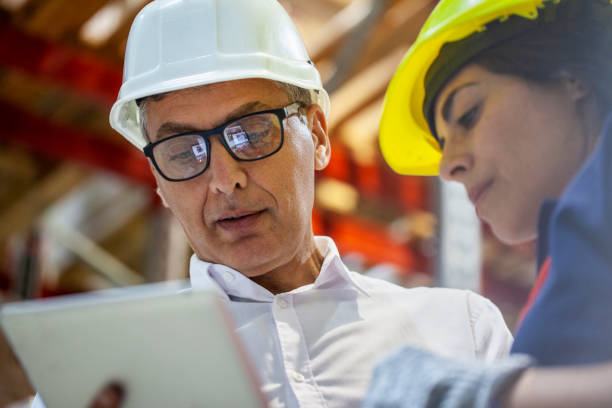istock Low angle view of warehouse manager checking deliveries with female storage packer 1754238702
