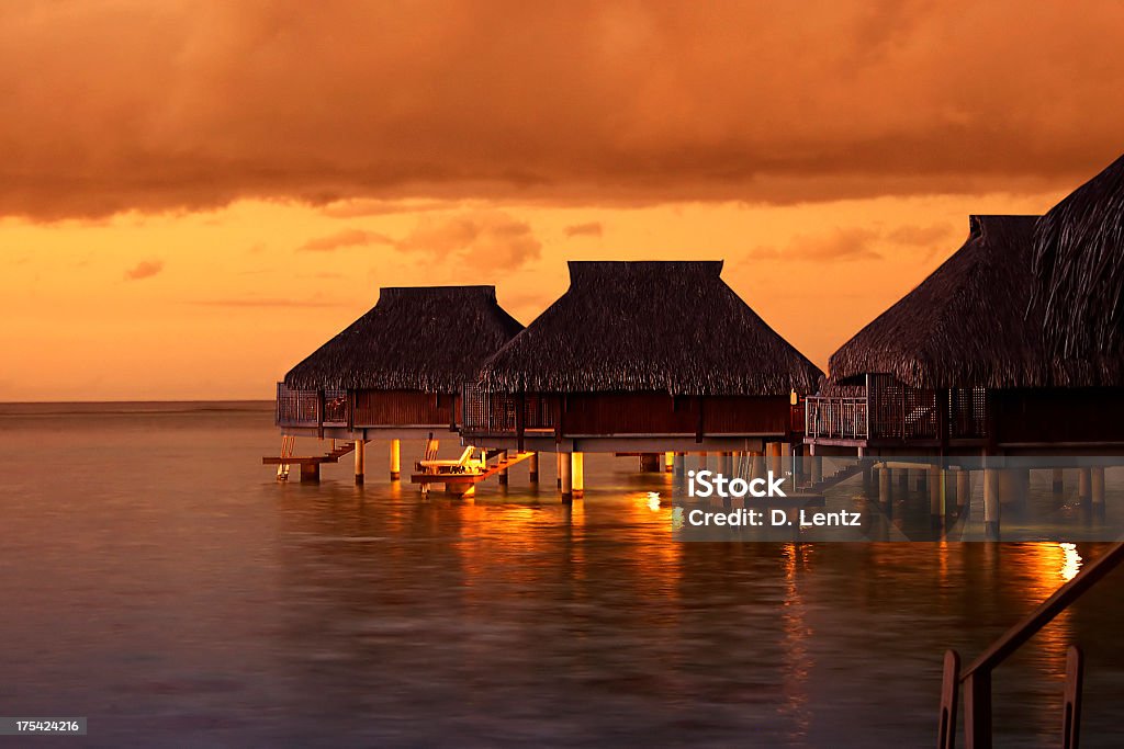 Water houses in the Tahiti Sunset Tropical Tahiti bungalows at sunset Tahiti Stock Photo