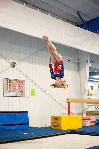 Young Gymnast Doing Backflip on Trampoline stock photo