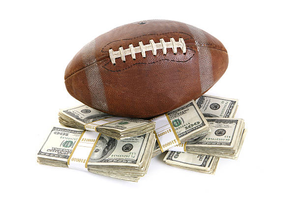 Fantasy Football Champion Football on top of stacks of cash with money wrappers. sports betting stock pictures, royalty-free photos & images