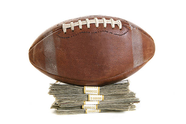 Leather football on top of cash.