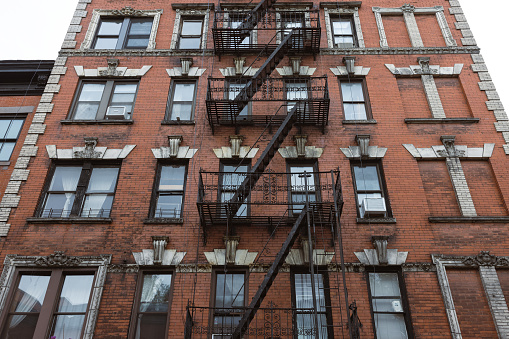 Characteristic historic West Village front stoop buildings with metal fire ladders, Manhattan, NYC