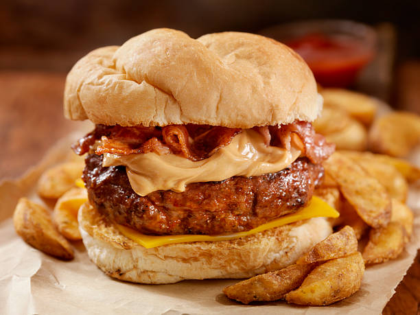 Peanut Butter Bacon Burger Peanut Butter Bacon Burger on a toasted Kaiser Bun with Wedge cut French Fries-Photographed on Hasselblad H3D-39mb Camera bacon cheeseburger stock pictures, royalty-free photos & images
