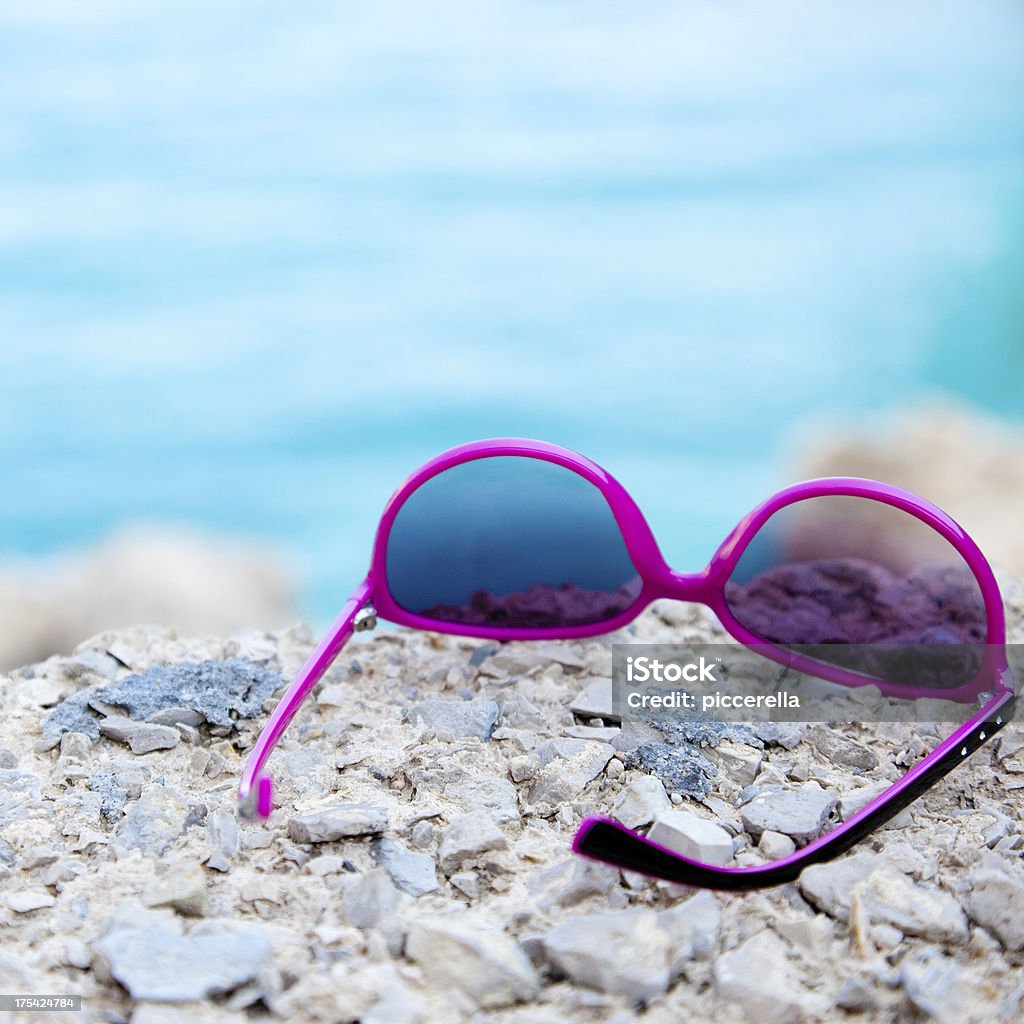 Sunglasses on the Seaside Sunglasses on a rock near by the sea. Beach Stock Photo