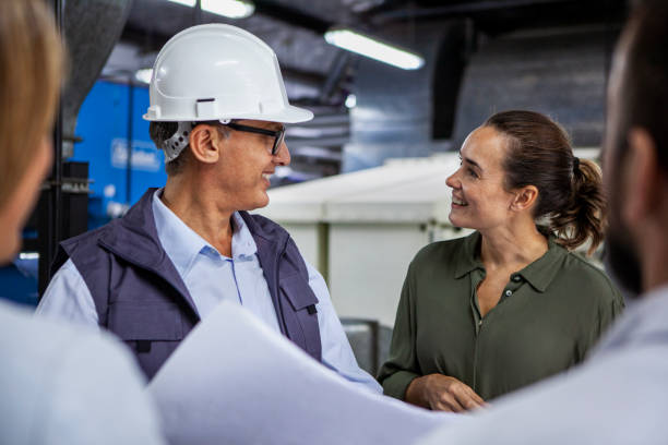 istock Warehouse manager looking blueprints with female architect 1754248619