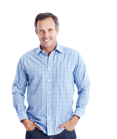 A good-natured mature man with his hands in his pockets isolated on a white background