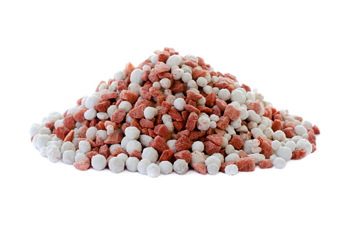 Potassium chloride and superphosphate isolated on white background. Close-up of red and white color mineral fertilizer, top view. Heap of potassium chloride and superphosphate on a white background