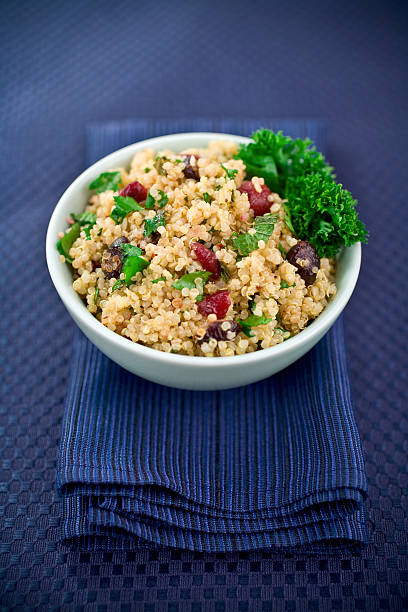 White bowl of Quinoa Salad resting on a thick blue napkin