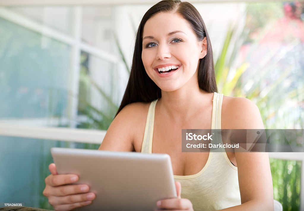 Giovane donna utilizzando una tavoletta digitale - Foto stock royalty-free di Adulto