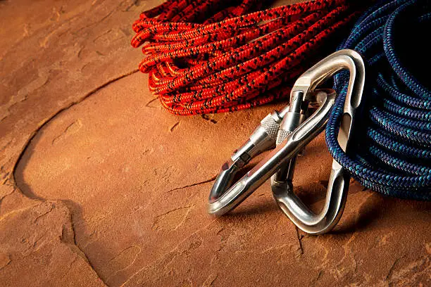 This is a close up photo taken in the studio of rope and carabiner clips on a red rocks.Click on the links below to view lightboxes.