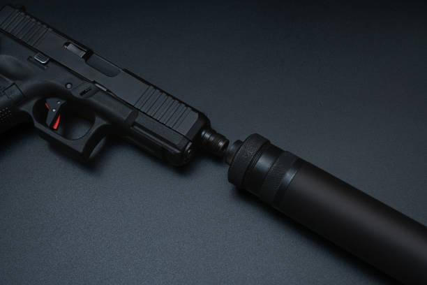 istock Pistol with silencer on the black desk 1754271951