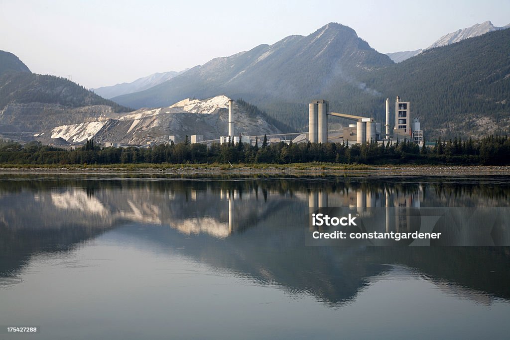 Industrial cemento planta con reflejos de las montañas. - Foto de stock de Contaminación ambiental libre de derechos